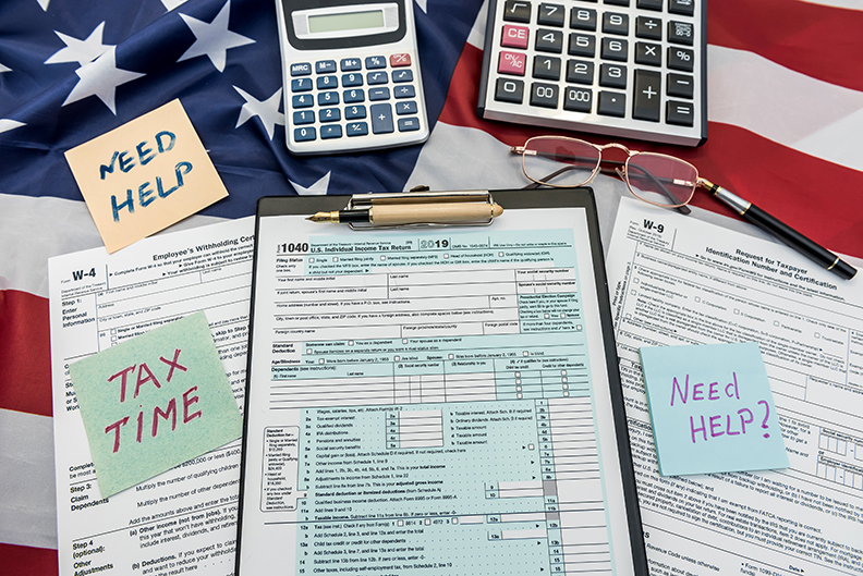finance document 1040 tax form with pen and calculator on flag of USA finance document 1040 tax form with pen and calculator on flag of USA. Deadline